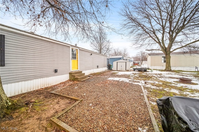 yard layered in snow featuring a storage unit