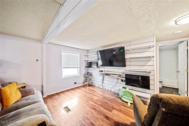 living room with wood-type flooring and a textured ceiling