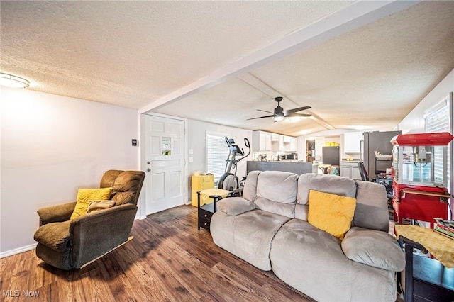 living room with ceiling fan, dark hardwood / wood-style floors, a textured ceiling, and vaulted ceiling with beams