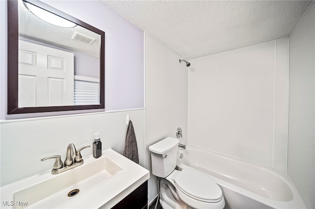 full bathroom with vanity,  shower combination, toilet, and a textured ceiling