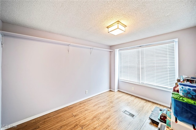 interior space featuring a textured ceiling and light wood-type flooring