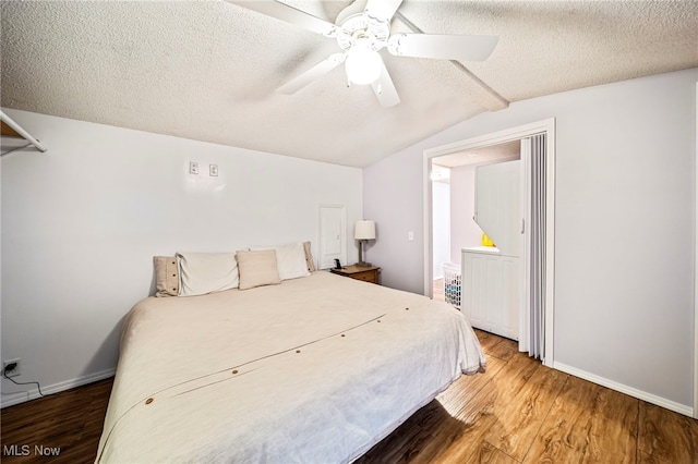 bedroom with lofted ceiling, ceiling fan, hardwood / wood-style flooring, and a textured ceiling