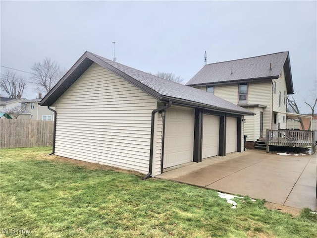 view of home's exterior featuring a wooden deck, a garage, a yard, and an outbuilding