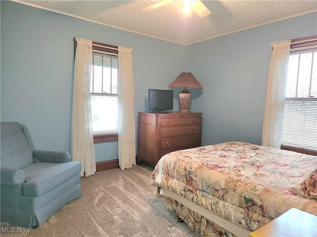 carpeted bedroom featuring crown molding and ceiling fan