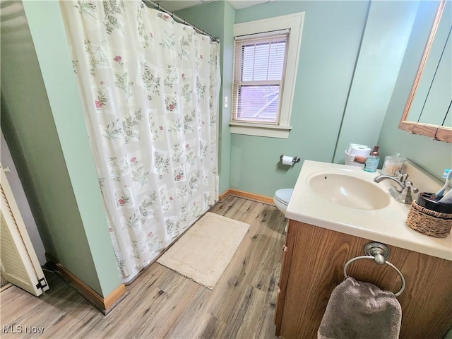 bathroom with a shower with curtain, wood-type flooring, vanity, and toilet