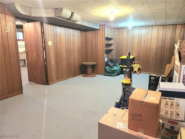 basement featuring wood walls