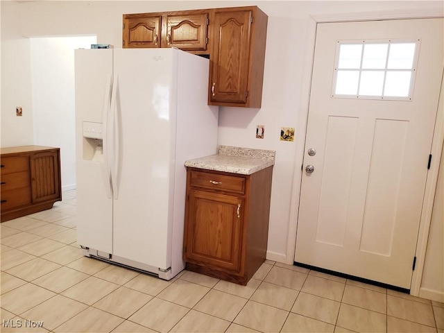 kitchen featuring white refrigerator with ice dispenser and light tile patterned flooring