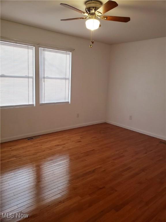 unfurnished room with wood-type flooring and ceiling fan