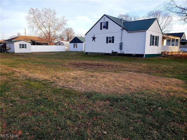 view of yard with central AC and an outbuilding