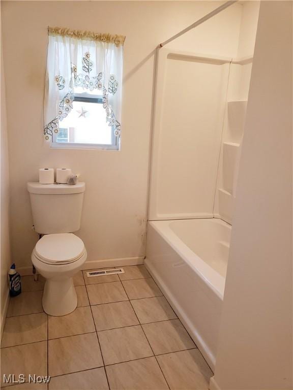 bathroom featuring shower / tub combination, tile patterned floors, and toilet