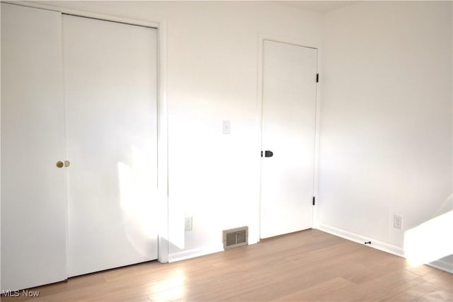 unfurnished bedroom with a closet and light hardwood / wood-style flooring