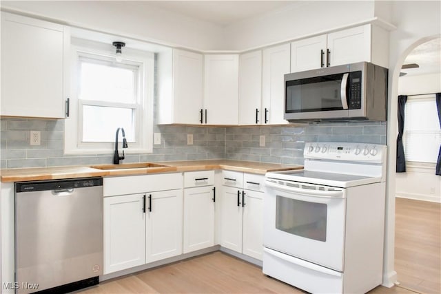 kitchen featuring plenty of natural light, stainless steel appliances, sink, and white cabinets