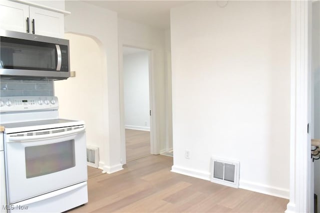 kitchen featuring decorative backsplash, white electric range, light hardwood / wood-style flooring, and white cabinets