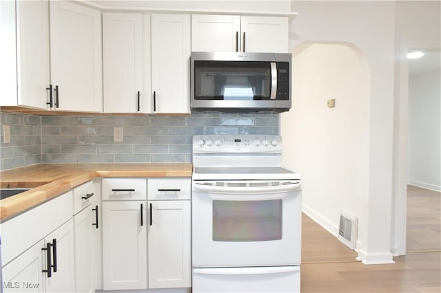 kitchen featuring tasteful backsplash, wooden counters, white electric range oven, and white cabinets