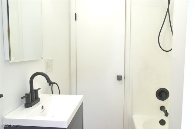 bathroom featuring bathing tub / shower combination and vanity