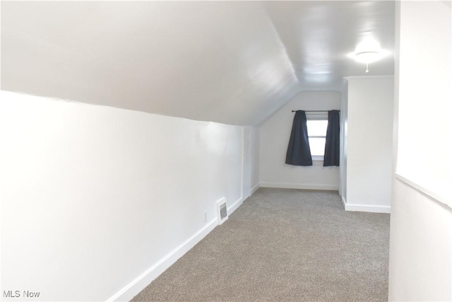 bonus room featuring vaulted ceiling and light colored carpet