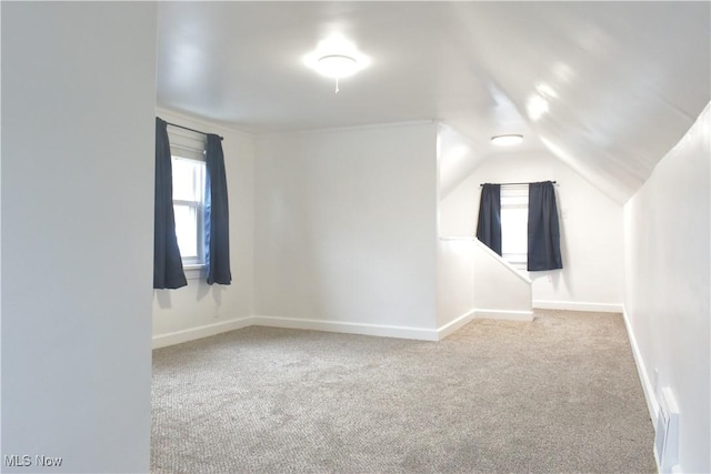 additional living space with vaulted ceiling and light colored carpet