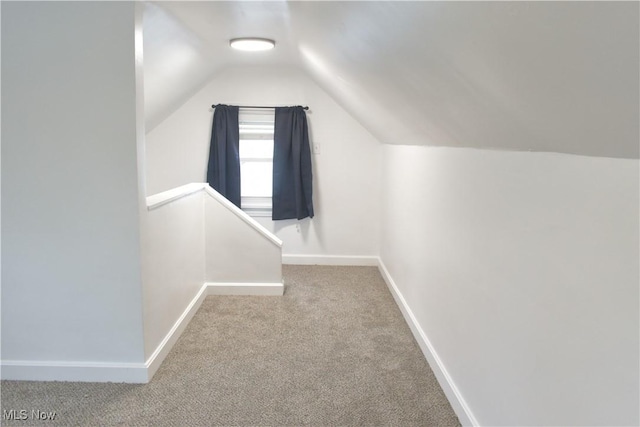 interior space featuring lofted ceiling and light carpet