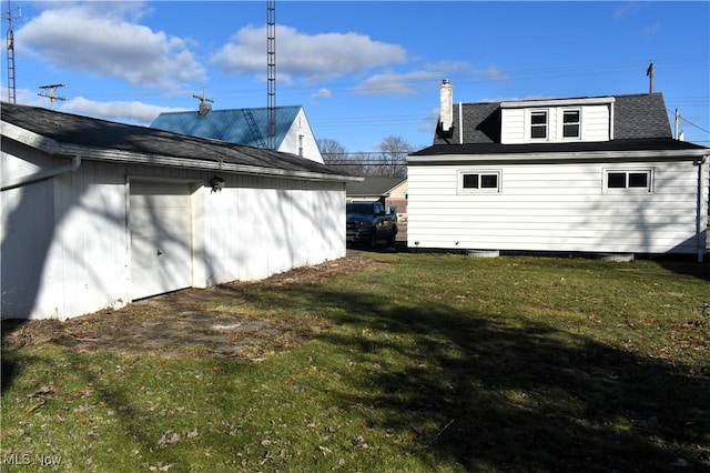 view of side of property featuring a garage and a yard