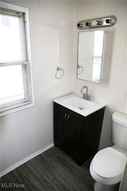 bathroom with hardwood / wood-style flooring, plenty of natural light, toilet, and vanity