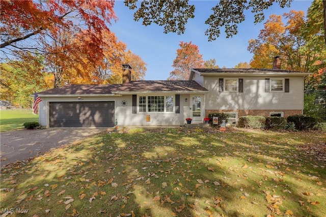 split level home with a garage and a front lawn