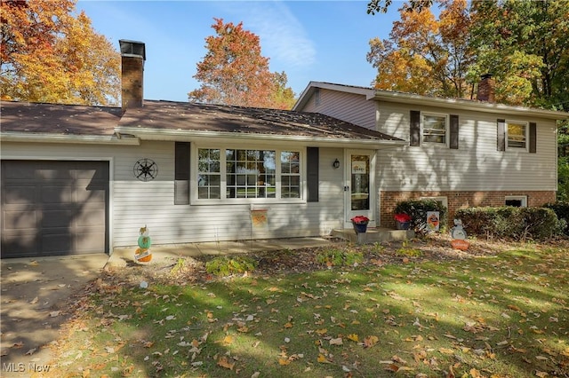 split level home with a garage and a front lawn