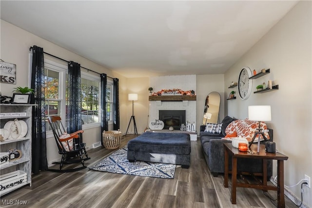 living room with hardwood / wood-style floors and a brick fireplace