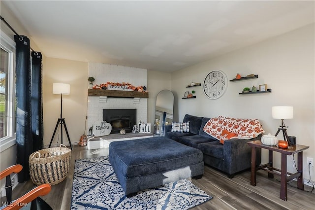 living room with wood-type flooring and a brick fireplace