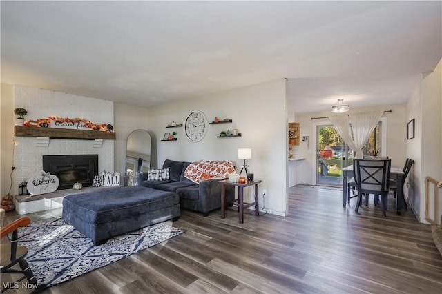 living room with dark wood-type flooring and a fireplace