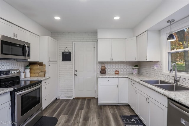 kitchen with decorative light fixtures, sink, white cabinets, stainless steel appliances, and dark wood-type flooring