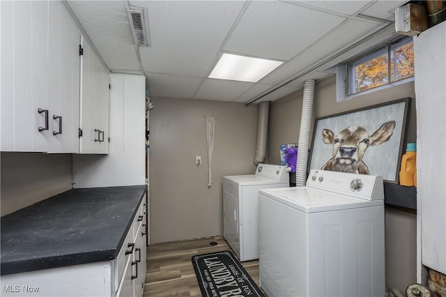 laundry room featuring cabinets, separate washer and dryer, and light hardwood / wood-style floors