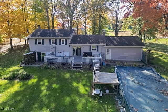 back of house featuring a wooden deck and a yard