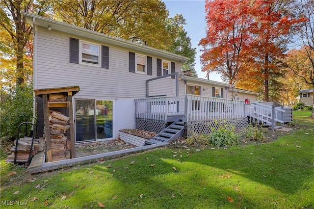 rear view of house featuring a deck and a lawn