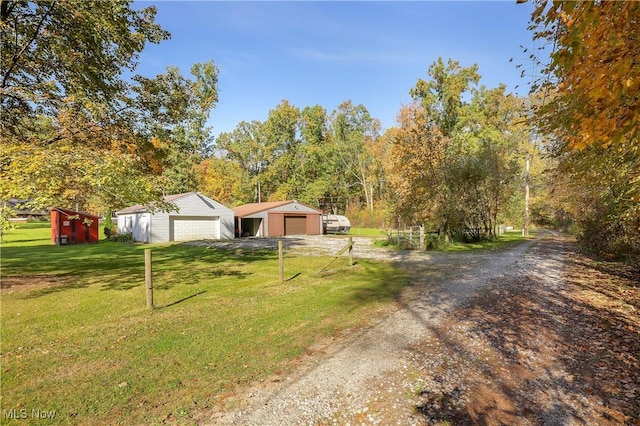 view of front of home with a garage, an outdoor structure, and a front yard