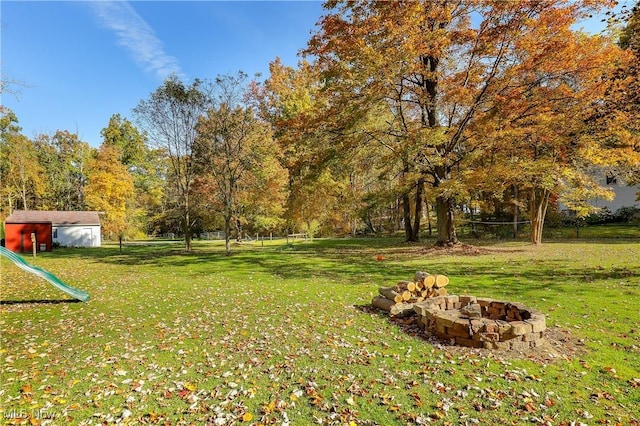 view of yard featuring a storage unit and a fire pit