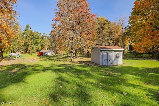 view of yard featuring a playground and a storage unit