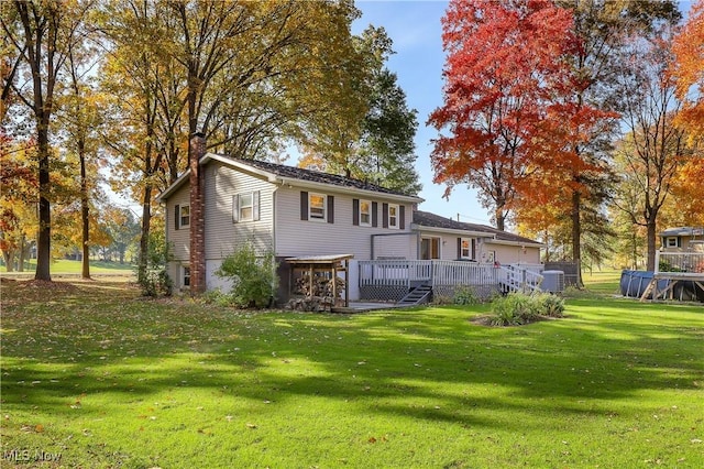 rear view of house featuring a yard and a deck