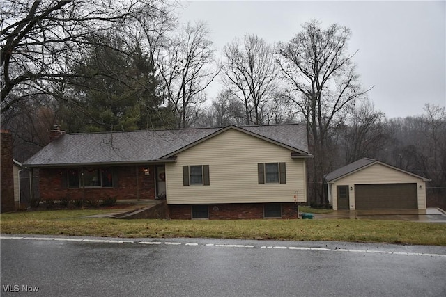 view of front of home with a garage, an outbuilding, and a front lawn