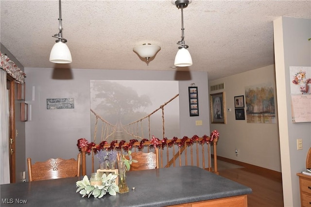 unfurnished dining area featuring hardwood / wood-style flooring and a textured ceiling