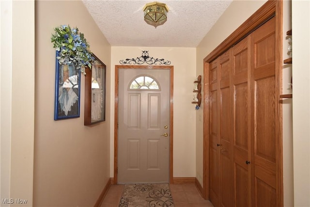 entryway featuring light tile patterned flooring and a textured ceiling