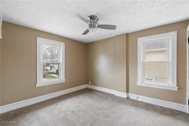 carpeted spare room featuring ceiling fan and a textured ceiling