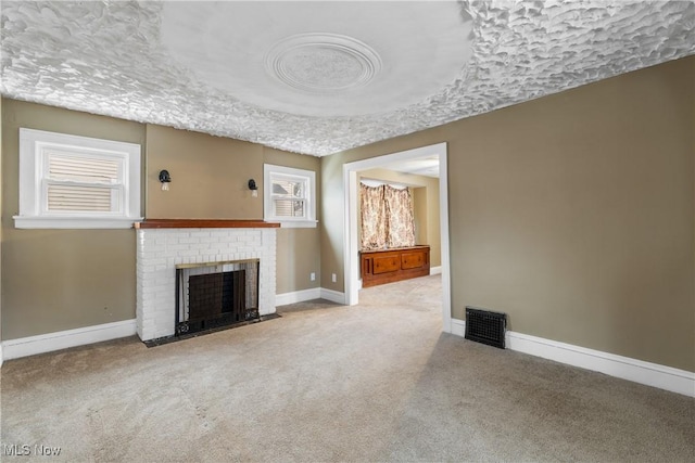 unfurnished living room featuring light colored carpet and a brick fireplace