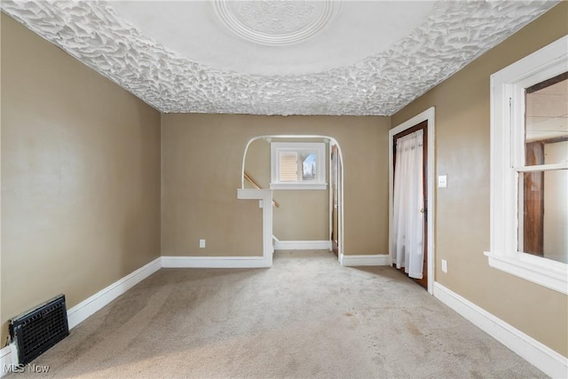 carpeted empty room with a textured ceiling