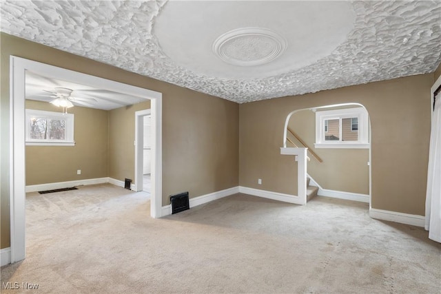 carpeted spare room featuring ceiling fan and a textured ceiling