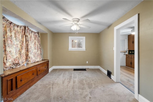 spare room with light colored carpet and ceiling fan