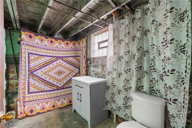 bathroom featuring vanity, concrete floors, and toilet