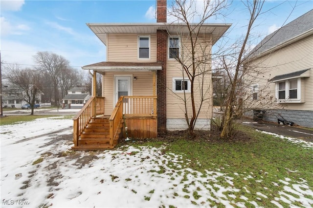 view of snow covered rear of property