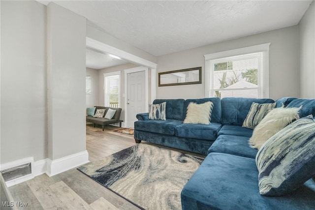 living room featuring light hardwood / wood-style floors and a textured ceiling