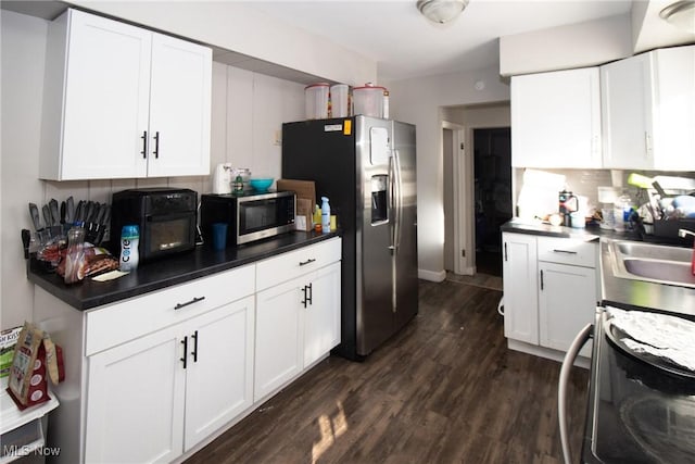 kitchen with appliances with stainless steel finishes, sink, white cabinets, and dark hardwood / wood-style floors