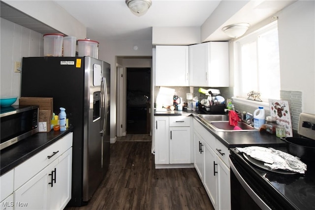 kitchen featuring white cabinetry, appliances with stainless steel finishes, dark wood-type flooring, and sink